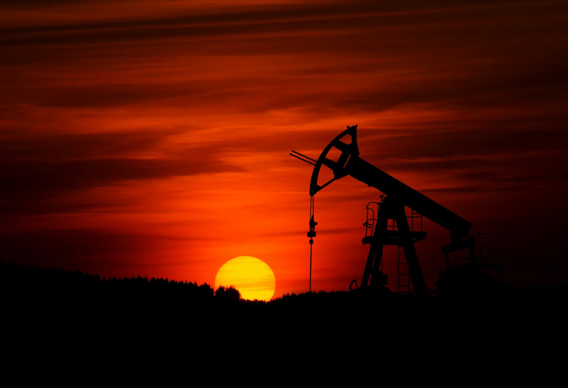 Oil pump silhouette at sunset representing crude oil supply and energy procurement