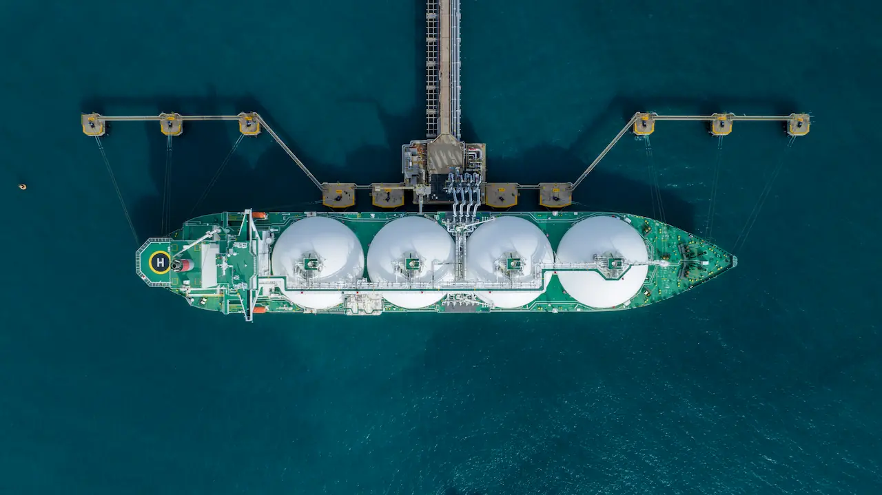 Aerial view of an LNG tanker berthed at a gas terminal